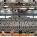 Widownia i scena Teatru Nowego w Warszawie. Puste, szare fotele czekają na widzów.