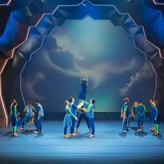 Tancerze na scenie Operetki Wrocławskiej w błękitnych strojach, tworząc żywą piramidę. Spektakularna scenografia.