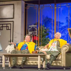 Aktorzy na scenie Teatru Komedia Wrocław, w barwnych strojach, przygotowują się do występu.