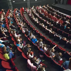 Widownia pełna dzieci i młodzieży, gotowa na spektakl w Bałtyckim Teatrze Dramatycznym.