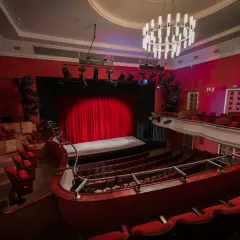 Widok na salę teatralną z czerwonymi fotelami i sceną. Teatr im. Stefana Jaracza w Łodzi czeka na widzów.