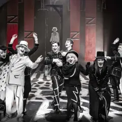 Aktorzy w teatralnych strojach, z mocnym makijażem, na scenie. Spektakl z repertuaru Teatru Starego w Krakowie.