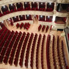 Widok z góry na bogato zdobione wnętrze Teatru im. Juliusza Słowackiego w Krakowie. Puste, czerwone fotele czekają na widzów, gotowe na kolejne spektakle.