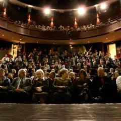 Widownia teatru pełna widzów, zastanawiających się, gdzie najlepiej siedzieć w teatrze, by mieć najlepszy widok.