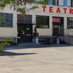 Teatr Druga Strefa. Budynek z czerwonym napisem "TEATR" na fasadzie, wejście z wielojęzycznym napisem "WEJŚCIE".