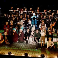 Aktorzy w strojach z epoki i orkiestra na scenie Teatru Dramatycznego w Płocku.