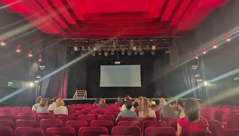 Widownia w Teatrze Palladium w Warszawie. Czerwone fotele i scena z ekranem czekają na widzów.