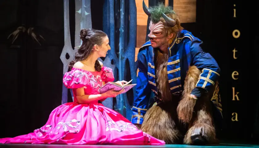 Piękna Bella w różowej sukni czyta Bestii z poznańskiego Teatru Muzycznego. Sprawdź repertuar!