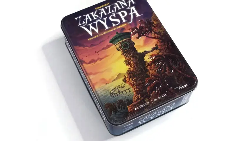 Metalowe pudełko gry planszowej "Zakazana Wyspa" z ilustracją wieży na klifie i palm.