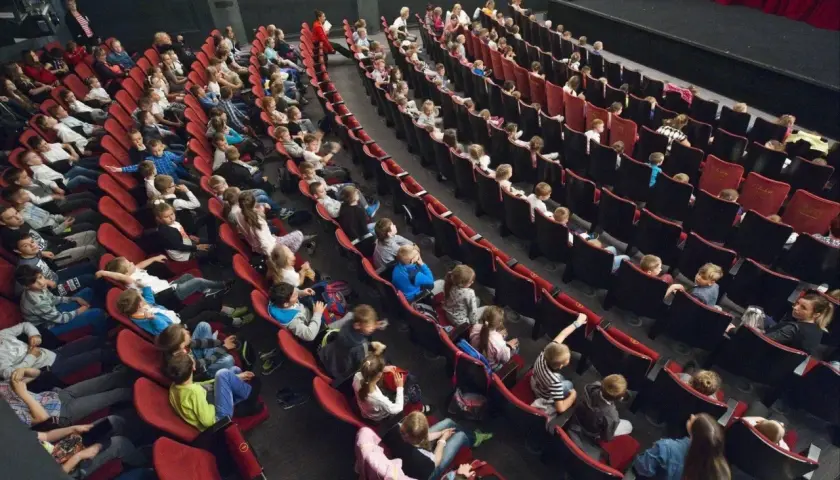 Widownia pełna dzieci i młodzieży, gotowa na spektakl w Bałtyckim Teatrze Dramatycznym.