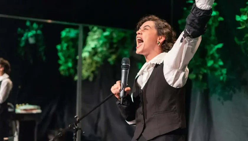 Aktorka z Teatru Lalki i Aktora w Opolu krzyczy do mikrofonu, prezentując emocjonujący fragment repertuaru.