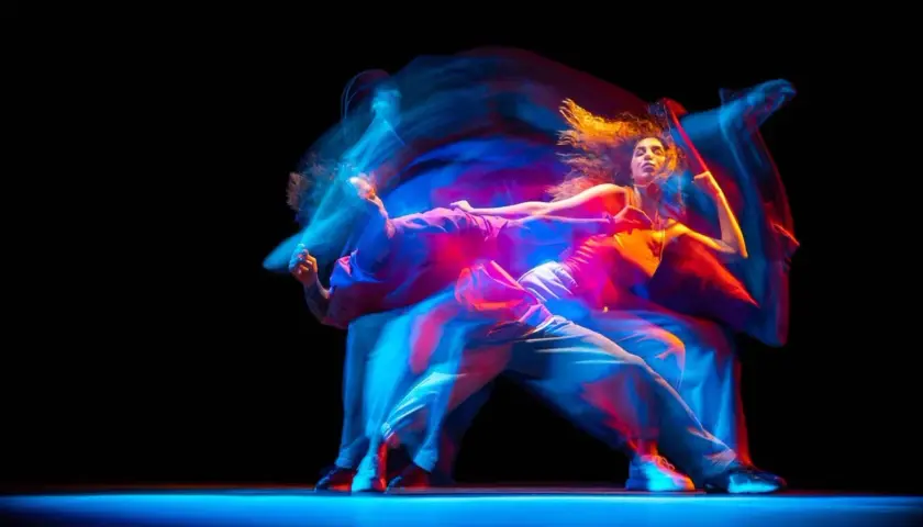 Tancerze w ruchu, tworzący świetlne smugi. Zastanawiasz się, ile zarabia choreograf tańca?