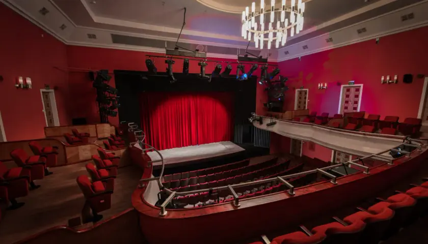 Widok na salę teatralną z czerwonymi fotelami i sceną. Teatr im. Stefana Jaracza w Łodzi czeka na widzów.