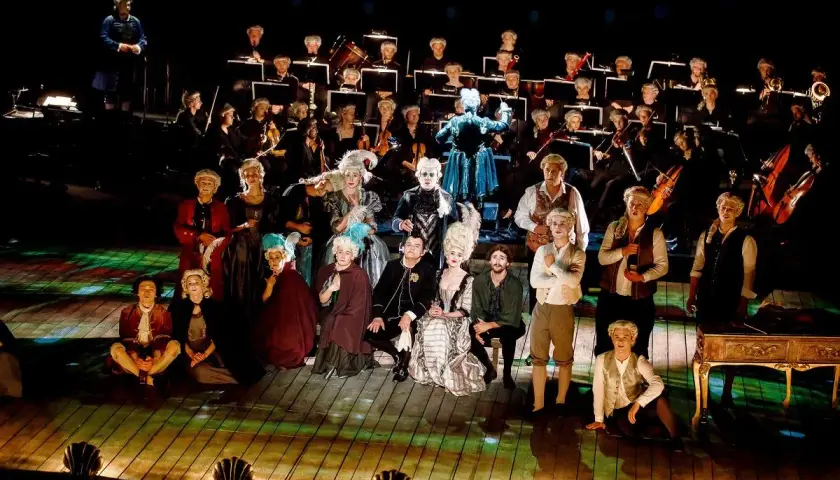 Aktorzy w strojach z epoki i orkiestra na scenie Teatru Dramatycznego w Płocku.