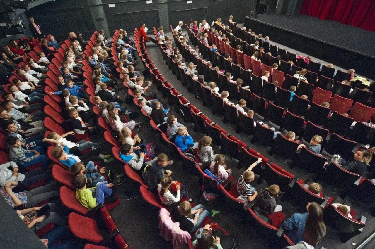 Widownia pełna dzieci i młodzieży, gotowa na spektakl w Bałtyckim Teatrze Dramatycznym.